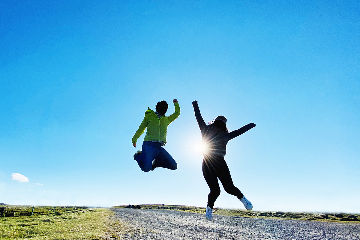 青空のもとでジャンプする若者の画像
