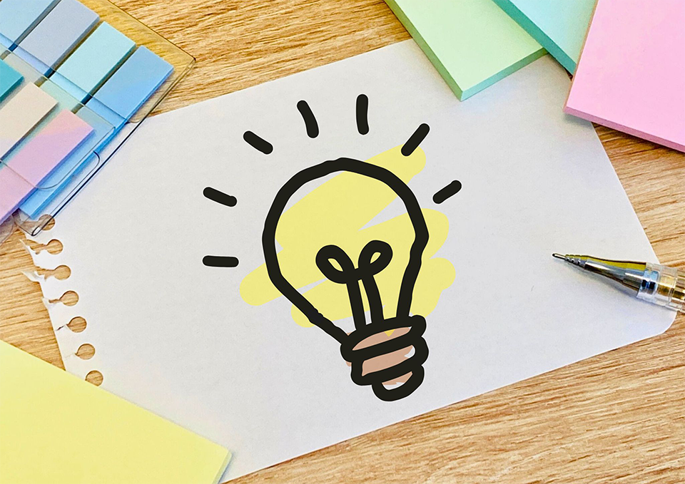 デスク上にファシリテーション実施のふせんなとの道具が拡がる画像